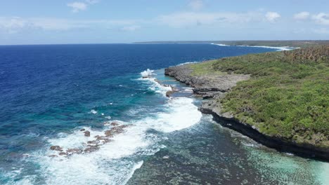 aerial view of south pacific ocean waves breaking on coast of tonga, polynesia