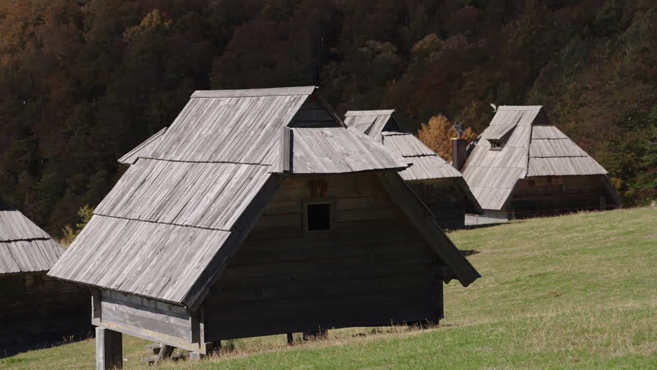 Footage of small wooden huts on green field in Kolašin during daytime