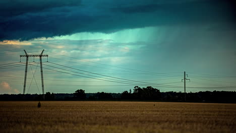 Storm-clouds-shower-rain-across-wheat-field-plains-at-sunset,-light-glistens-on-forest