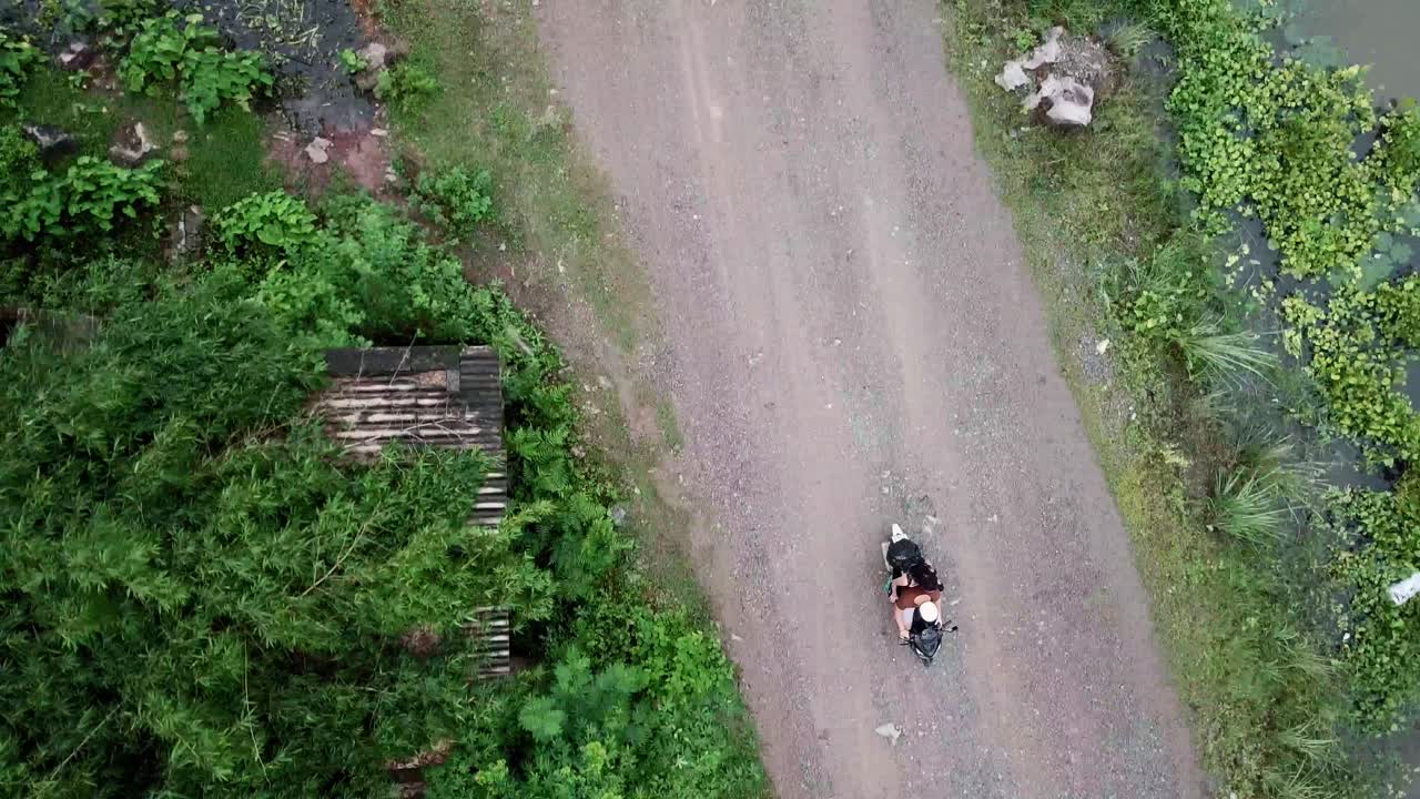 Birdseye view motorbike ride surrounded by river and houses in Vietnam
