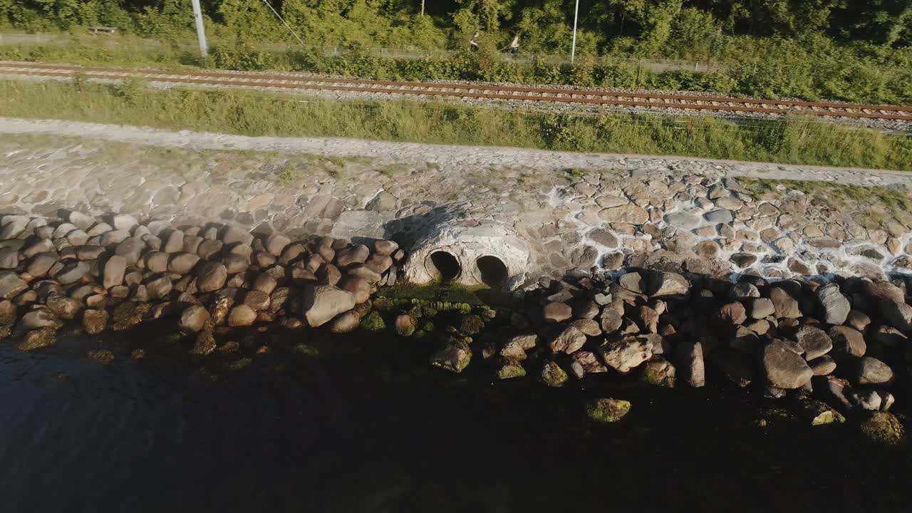 Breathtaking Drone Shot Sewage Outlet Surrounded by Rocks and River Waters