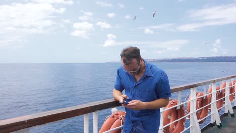 cámara lenta de un joven mirando el teléfono en un ferry.