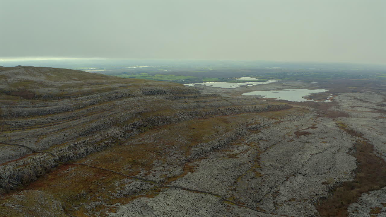 estableciendo una órbita aérea alrededor de mullaghmore, mostrando un turlough en el fondo en medio del paisaje rocoso del burren