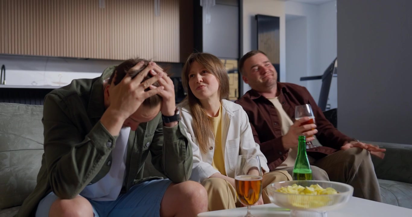 Venner ser tv og reagerer på et skuffende øjeblik.