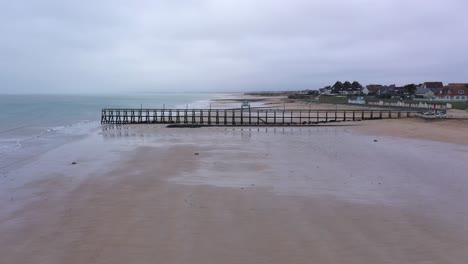 toma de drone de la playa de luc-sur-mer en normandía con vistas al muelle