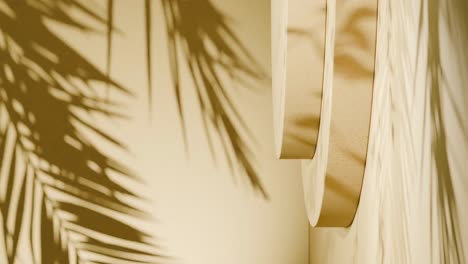 minimal yellow background with tropical palm leaf shadows and abstract geometric podium shapes. studio composition with natural light and soft contrast. vertical