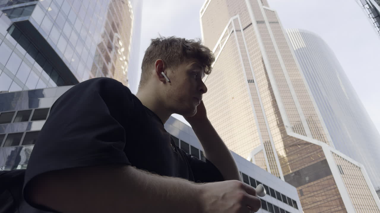 Man with Earbuds in a City