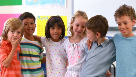 niños sonrientes de pie con el brazo alrededor en el aula
