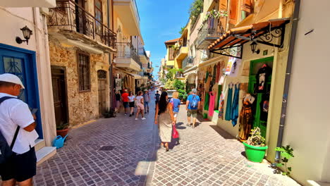 chania, crete, greece - tourists wandering through the narrow streets of the charming old town - drone flying forward