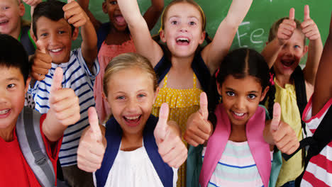 school kids showing thumbs up in classroom