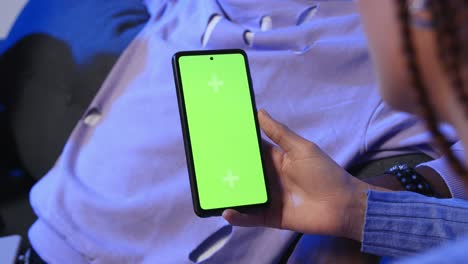 Close-Up-Of-Woman-With-Green-Screen-Mobile-Phone-Sitting-On-Sofa-At-Home-With-Friends