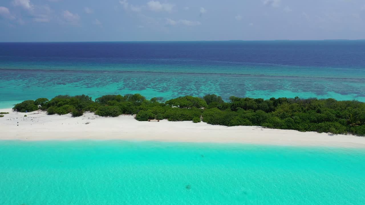 Bright azure lagoon and large coral reef around tiny tropical island with untouched white sandy beach and lush vegetation in the middle of Indian ocean