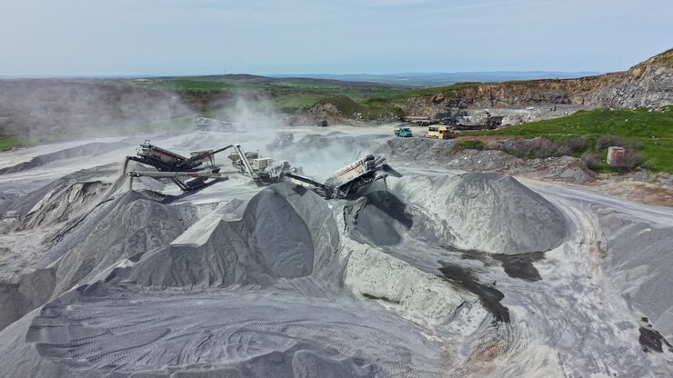 Granite quarry site showing machinery and stone piles during a sunny day