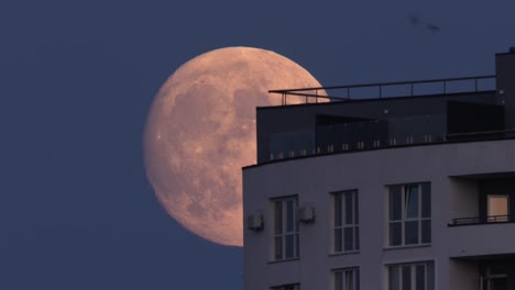 la luna llena que se levanta se mueve a través del techo de la casa.