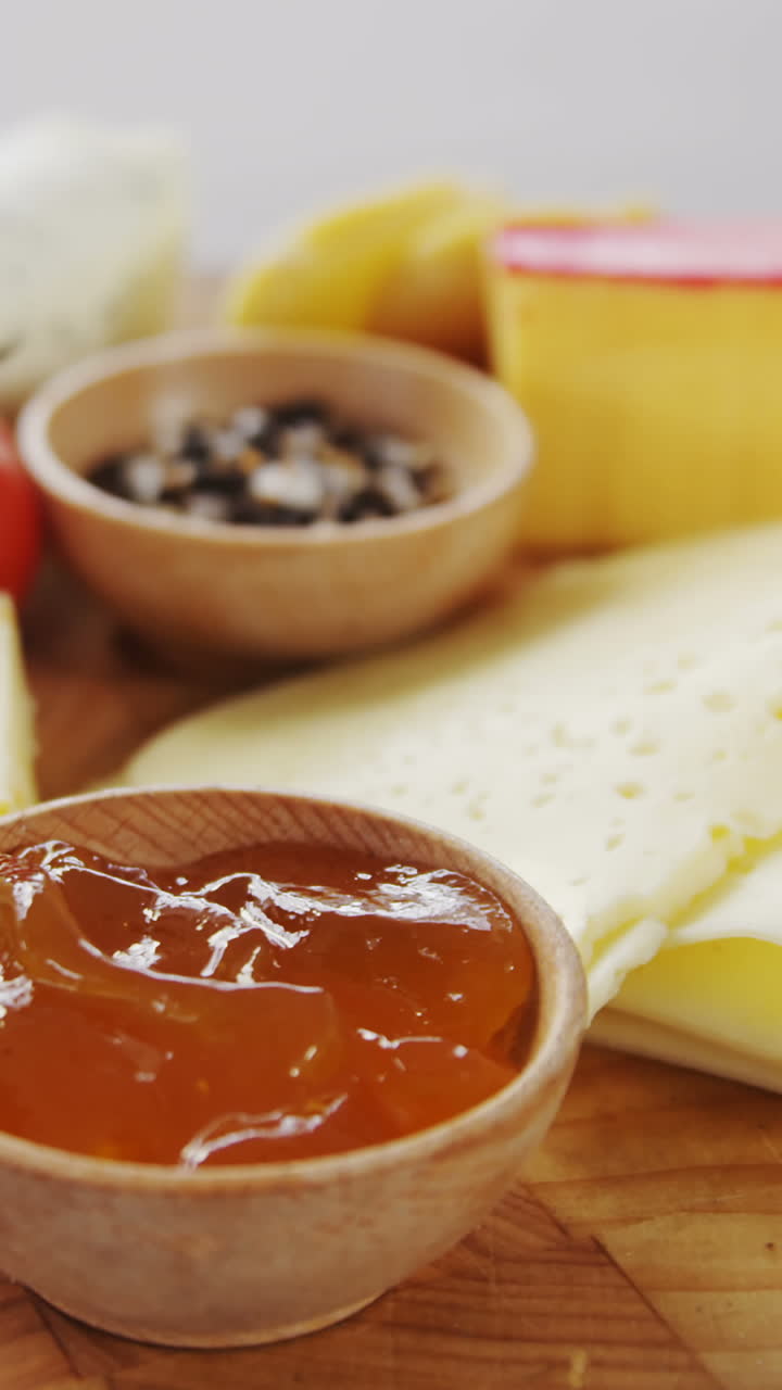 Different types of cheese, tomatoes and bowl of jam