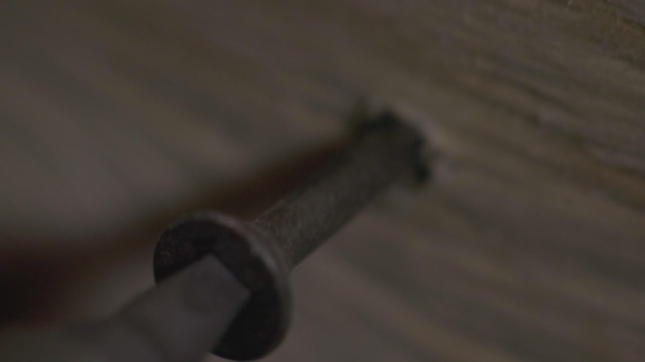 Person Screwing On the Corner Of the Wood Using A Black Screwdriver.- close up shot