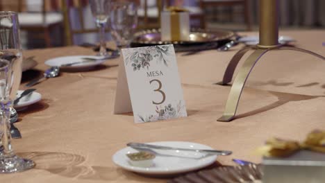 a table set for a wedding dinner and a sign with the number 3 in the center