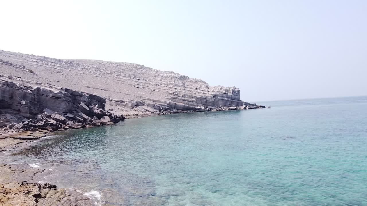 Drone shot of rocky desert beach and cliff in Oman