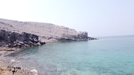 drone shot of rocky desert beach and cliff in oman