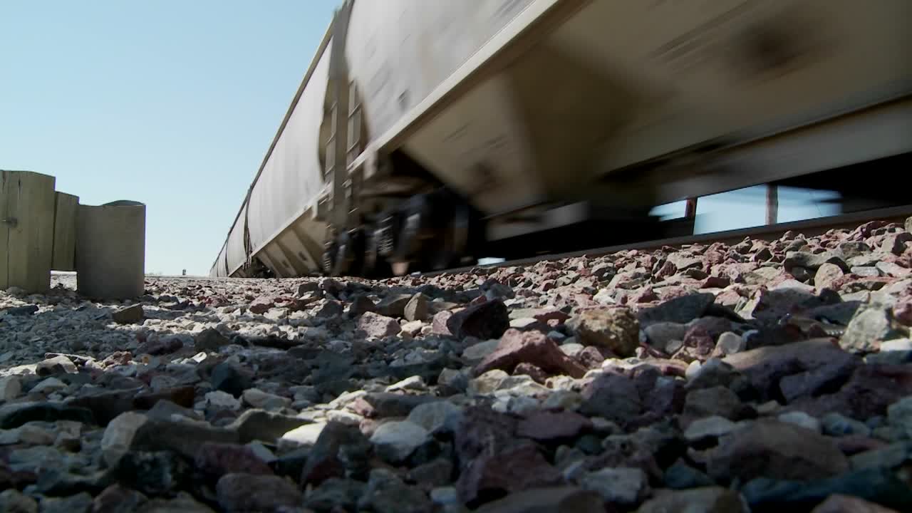 전경에서 노반과 함께 지나가는 기차의 낮은 각도