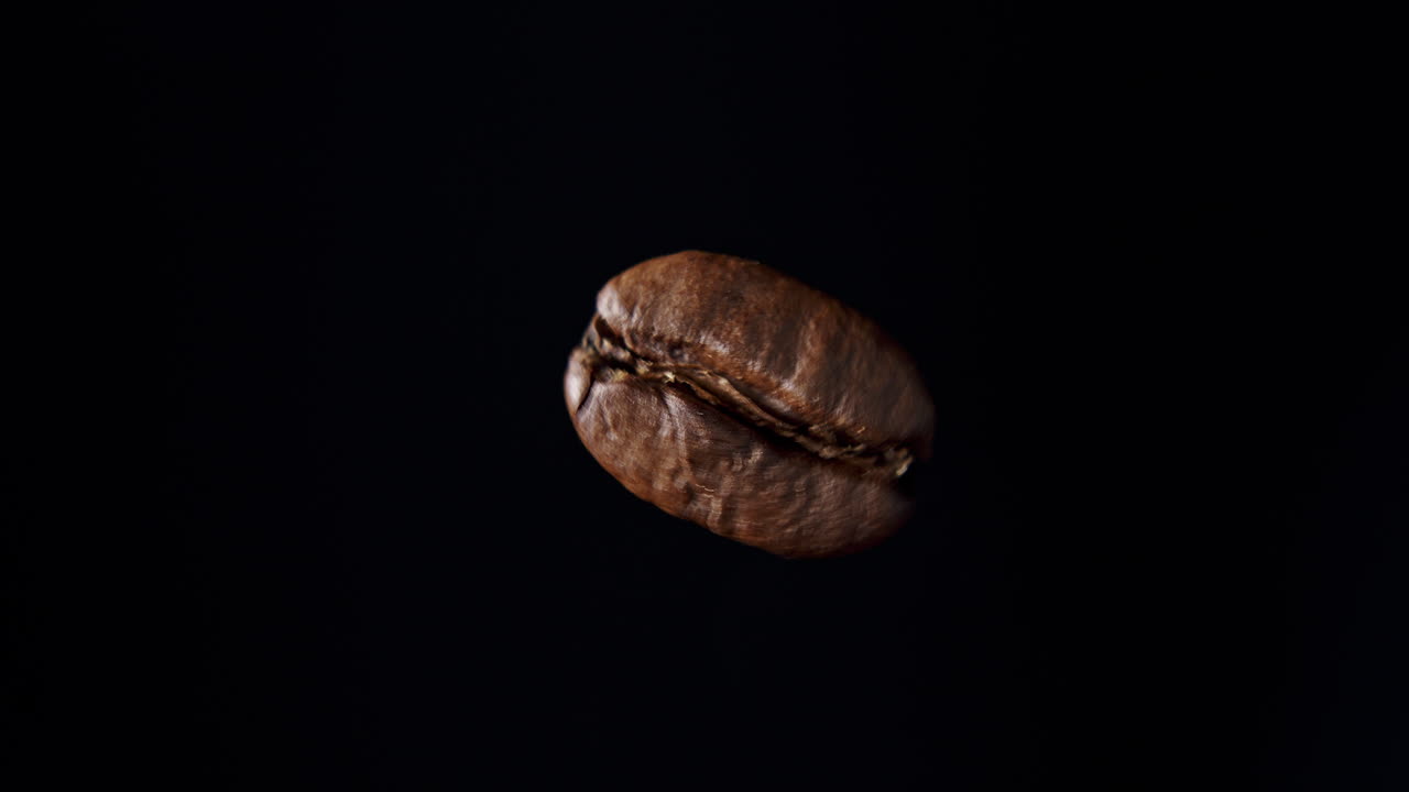 左邊有黑色背景和柔和的光線的旋轉咖啡豆的近距離拍攝
