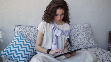young woman relaxing with tablet on bed