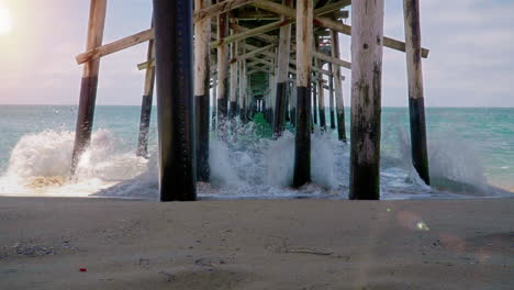 waves under a pier at new port beach in california