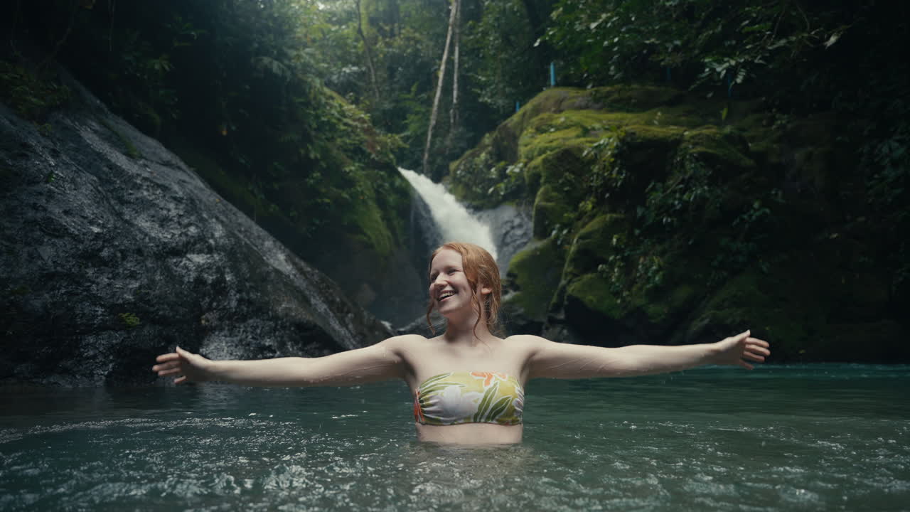 Woman enjoying a waterfall