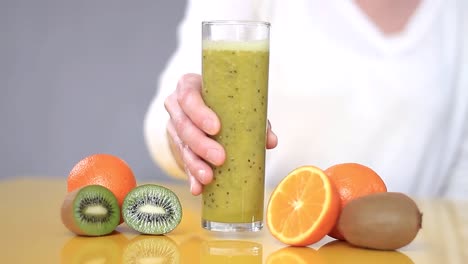 freshly squeezed orange and kiwi fruit juice in a glass on a table stock video stock footage