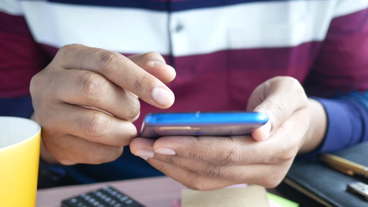 persona que utiliza un teléfono inteligente en un escritorio