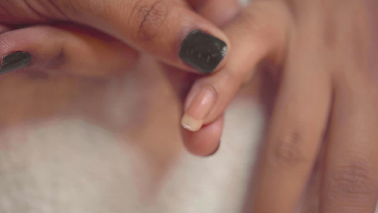 clienta se corta las uñas durante la manicura en el salón por esteticista