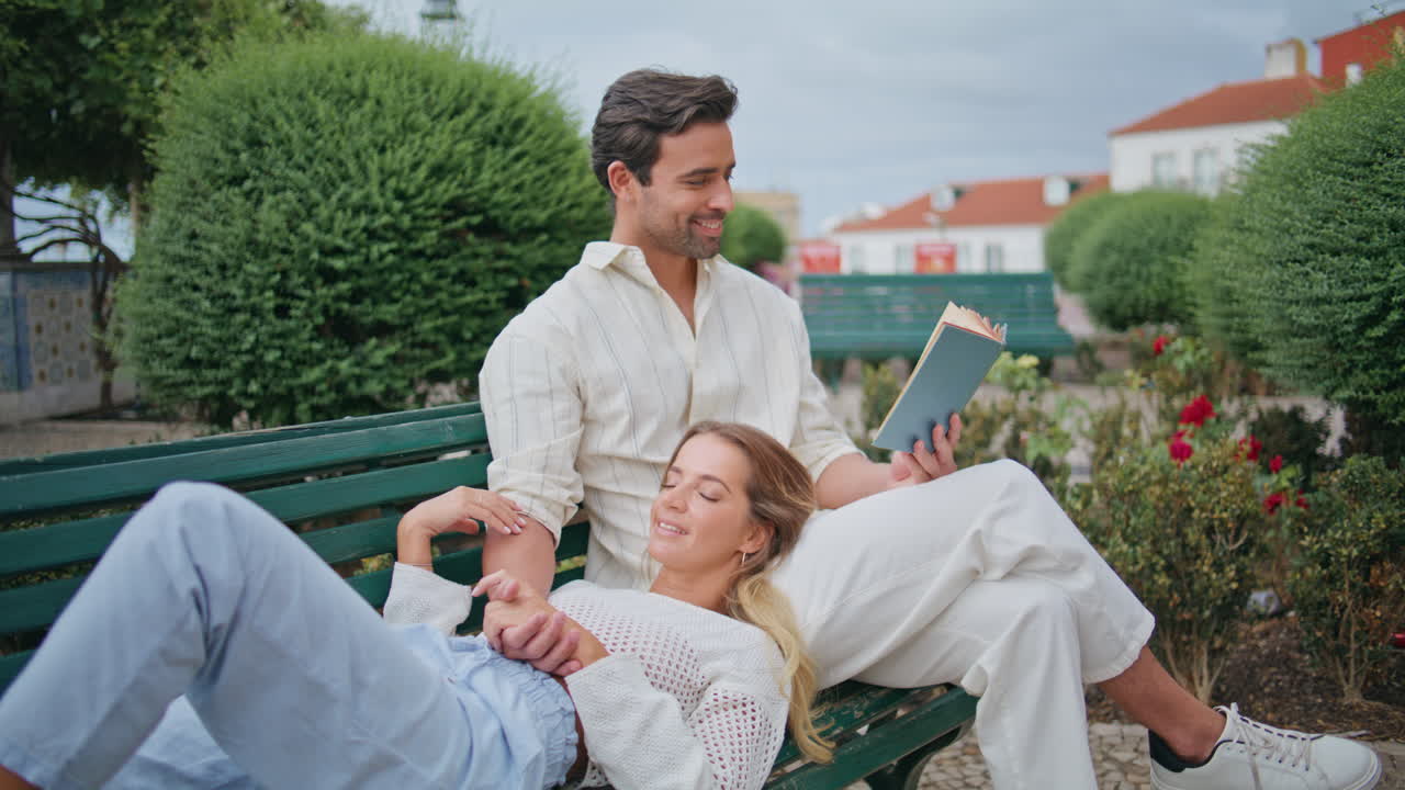 편안한 신혼부부는 소설 공원을 즐기고 있습니다. 남자친구에게 책을 읽습니다.