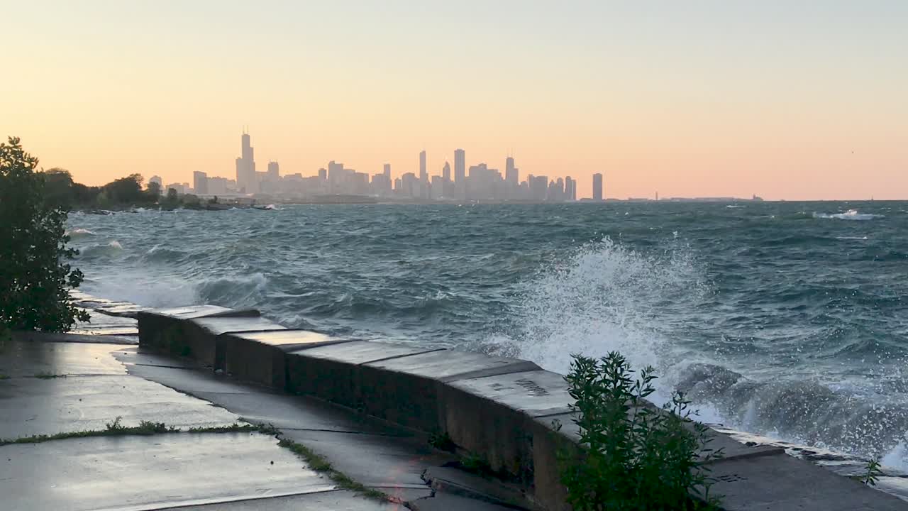 Lake Michigan waves crashing with Chicago skyline in the evening