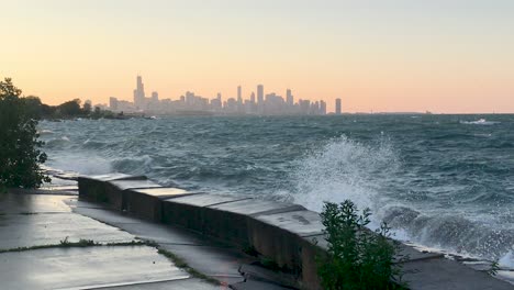 lake michigan waves crashing with chicago skyline in the evening