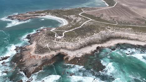 aerial shot of corny point lighthouse near the rocky shores of corny point and horse shoe bay