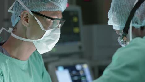 diverse surgeons with face masks during surgery in operating room in slow motion