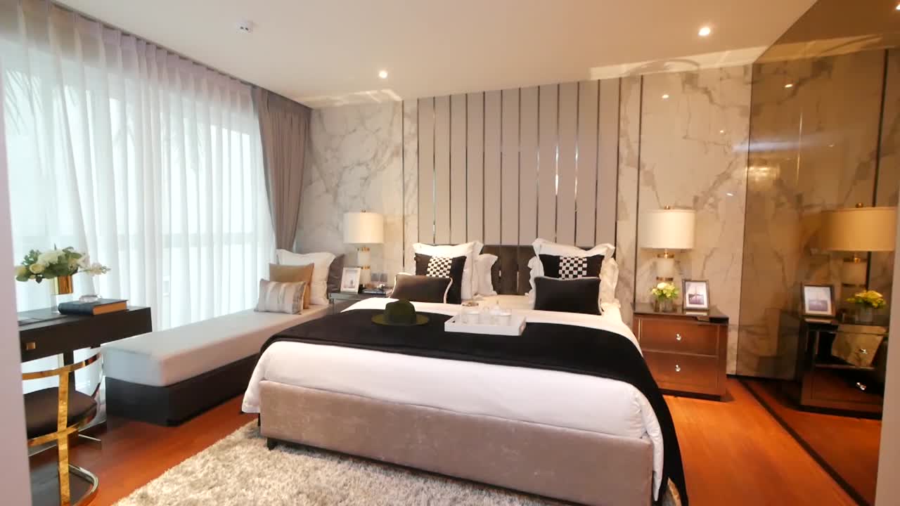 Bedroom furnished with the stylish bedding, couch and lighting furnitures