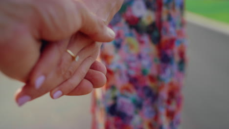 unknown man and woman holding hands in city park. love and care concept.