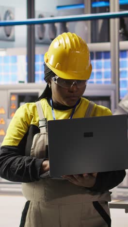 Vertical video Smiling smart factory specialist testing automated systems to ensure reliability