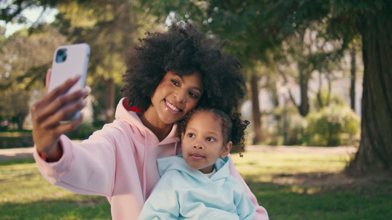 hija haciendo selfie en la naturaleza soleada de primer plano. madre haciendo foto de familia