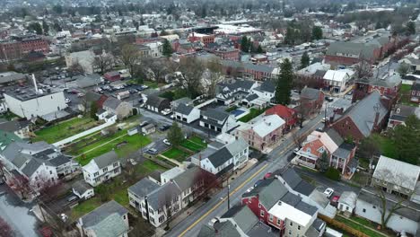 aerial flyover american town with historic buildings and homes in spring season