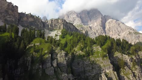 antena ascendente por un acantilado verde en una cordillera en un hermoso día soleado, san vito di cadore, tre cime, belluno, italia