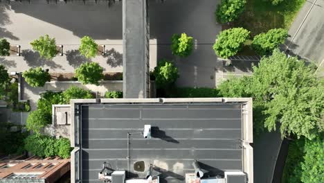 Drone-top-down-pan-from-sky-bridge-connecting-building-to-HVAC-piping-on-rooftop