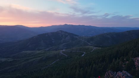 moving-forward-Aerial-drone-view-of-mountain-landscape-in-northern-Madrid,-Spain-with-hiker-silhouette-on-top-of-a-peak