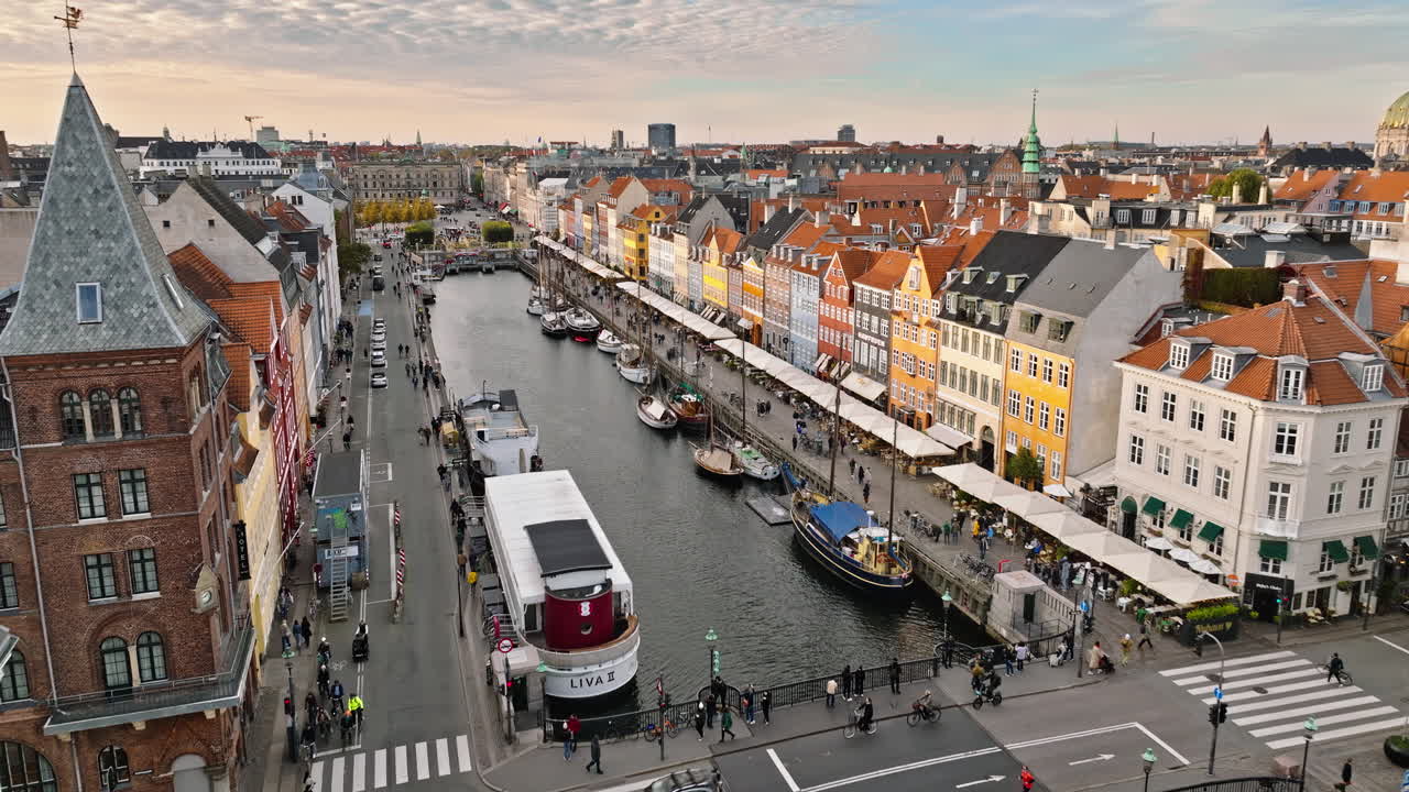Aerial drone view of boats on the Nyhavn waterfront, canal and entertainment district in Copenhagen, Denmark in daylight