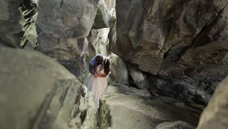 Groom-with-bride-standing-in-cave-of-mountain-hills.-Wedding-couple-in-love