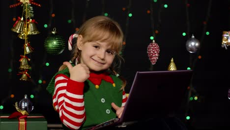 Niña-Vestida-De-Elfo-Navideño-Haciendo-Compras-En-Línea-Usando-Una-Computadora-Portátil,-Navegando-En-Las-Redes-Sociales