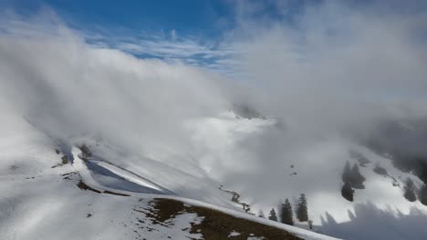 Circular-shot-of-snow-valley-and-pathway-with-misty-clouds,-Col-de-Porte