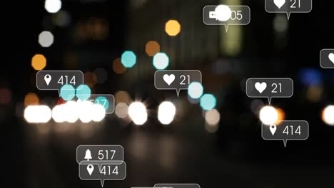 Animation-of-social-media-icons-and-numbers-over-out-of-focus-city-lights