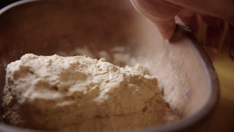 baking - kneading sourdough bread dough, turning bowl, slow motion close up